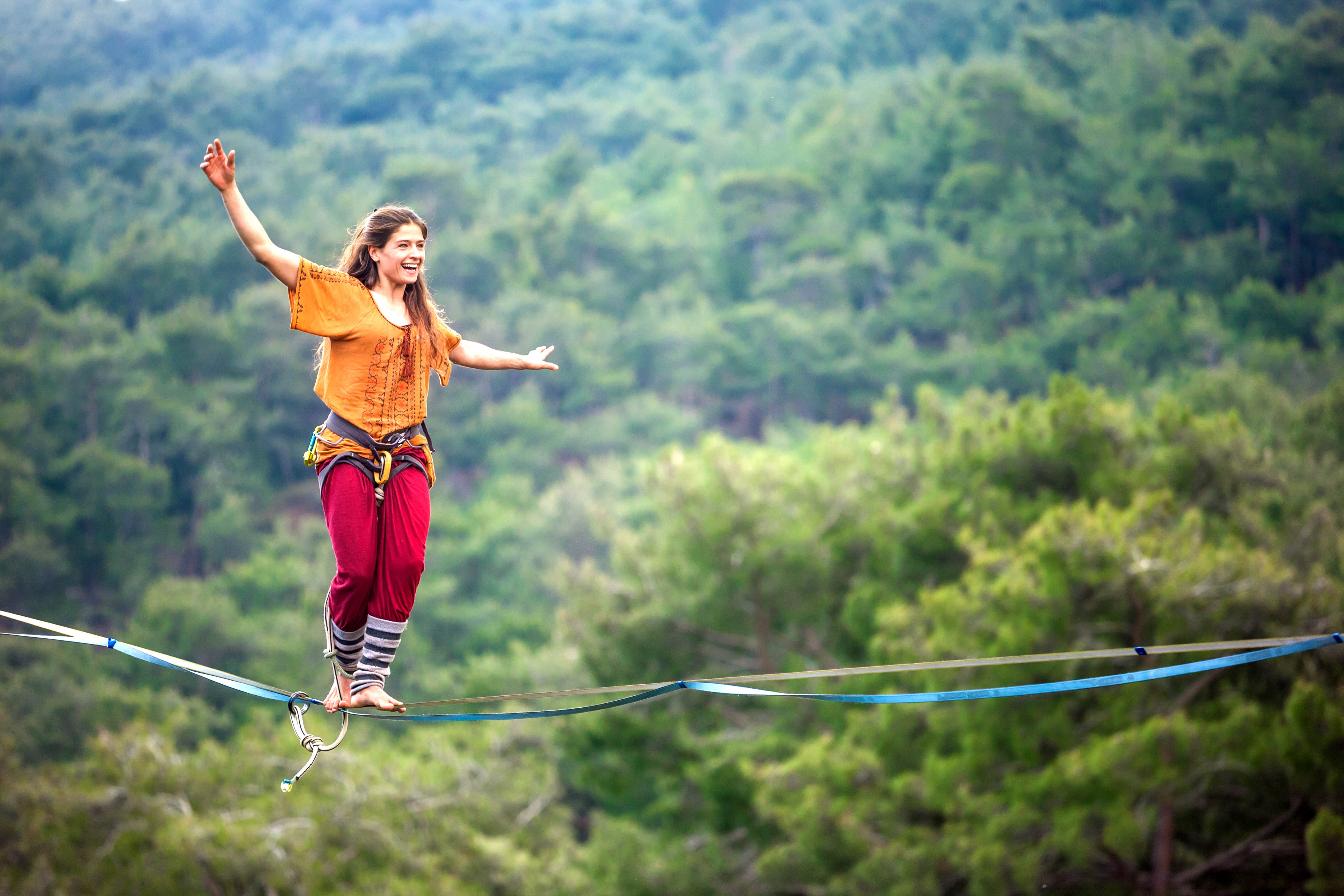 Young ,fit woman walking on a high wire over a canyon